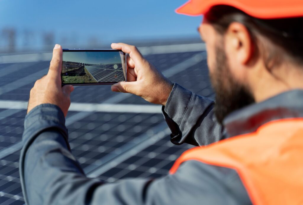Solar for Strata and Body Corporates on the Sunshine Coast 2 Person capturing a solar panel installation on a smartphone on the Sunshine Coast, showcasing modern and shareable solar installations.