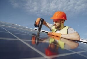 Skilled solar technician installing photovoltaic panels on a rooftop in the Sunshine Coast, highlighting professional solar installation services.