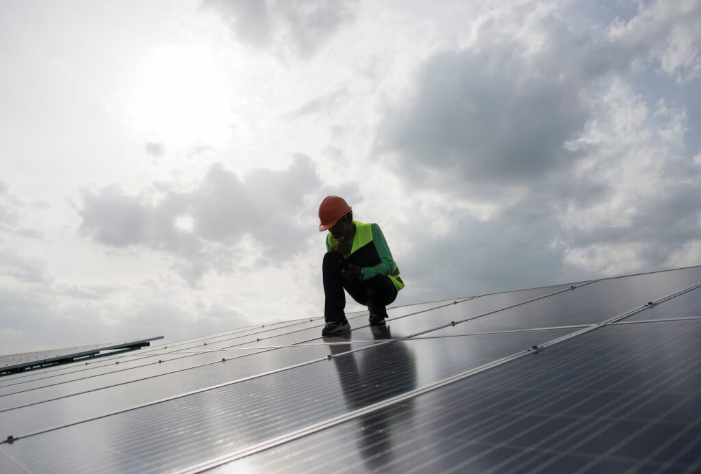 Technician inspecting a large solar array to ensure optimal performance and safety in a commercial solar installation on the Sunshine Coast.